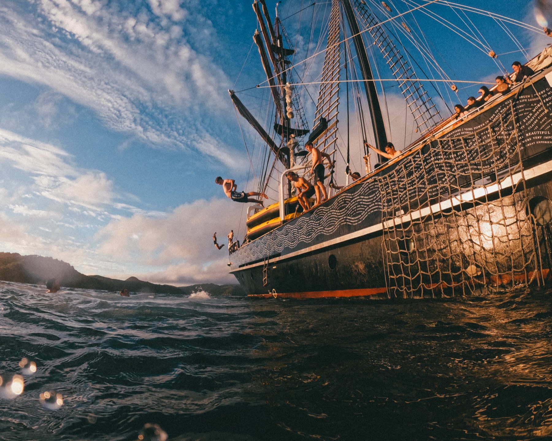 Trainees climbing the rigging and diving from the deck of the Spirit of New Zealand